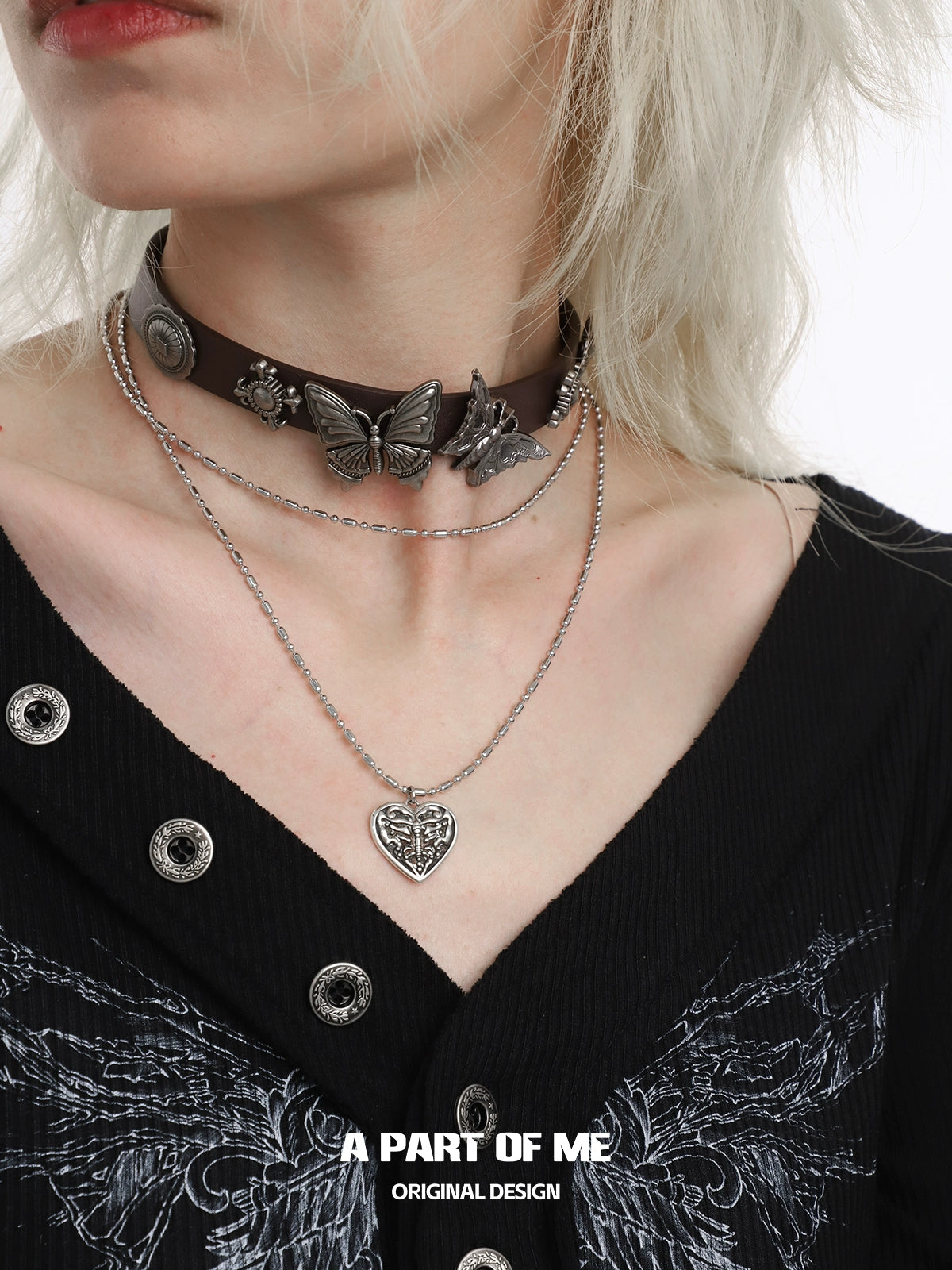 A PART OF ME butterfly punk necklace layered with a leather choker and silver chain for a stylish look