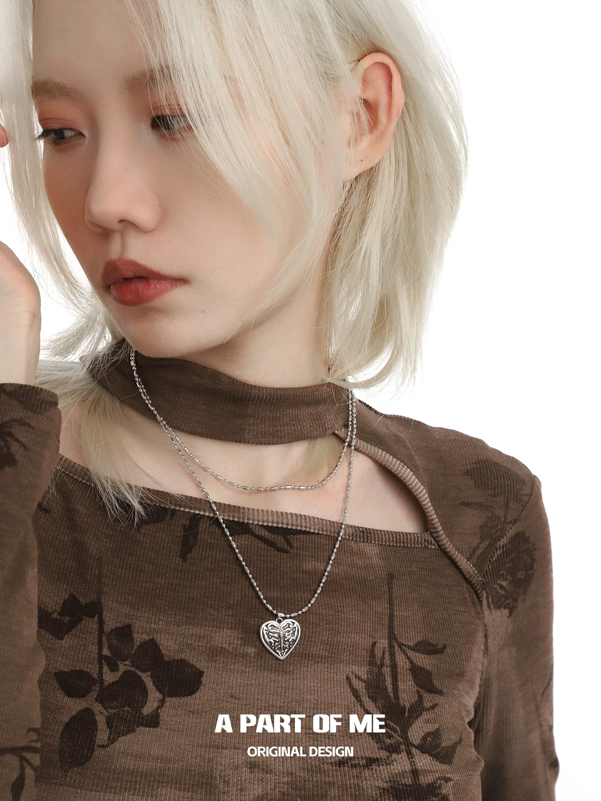 A model wearing a butterfly punk necklace with a heart pendant and layered silver chains