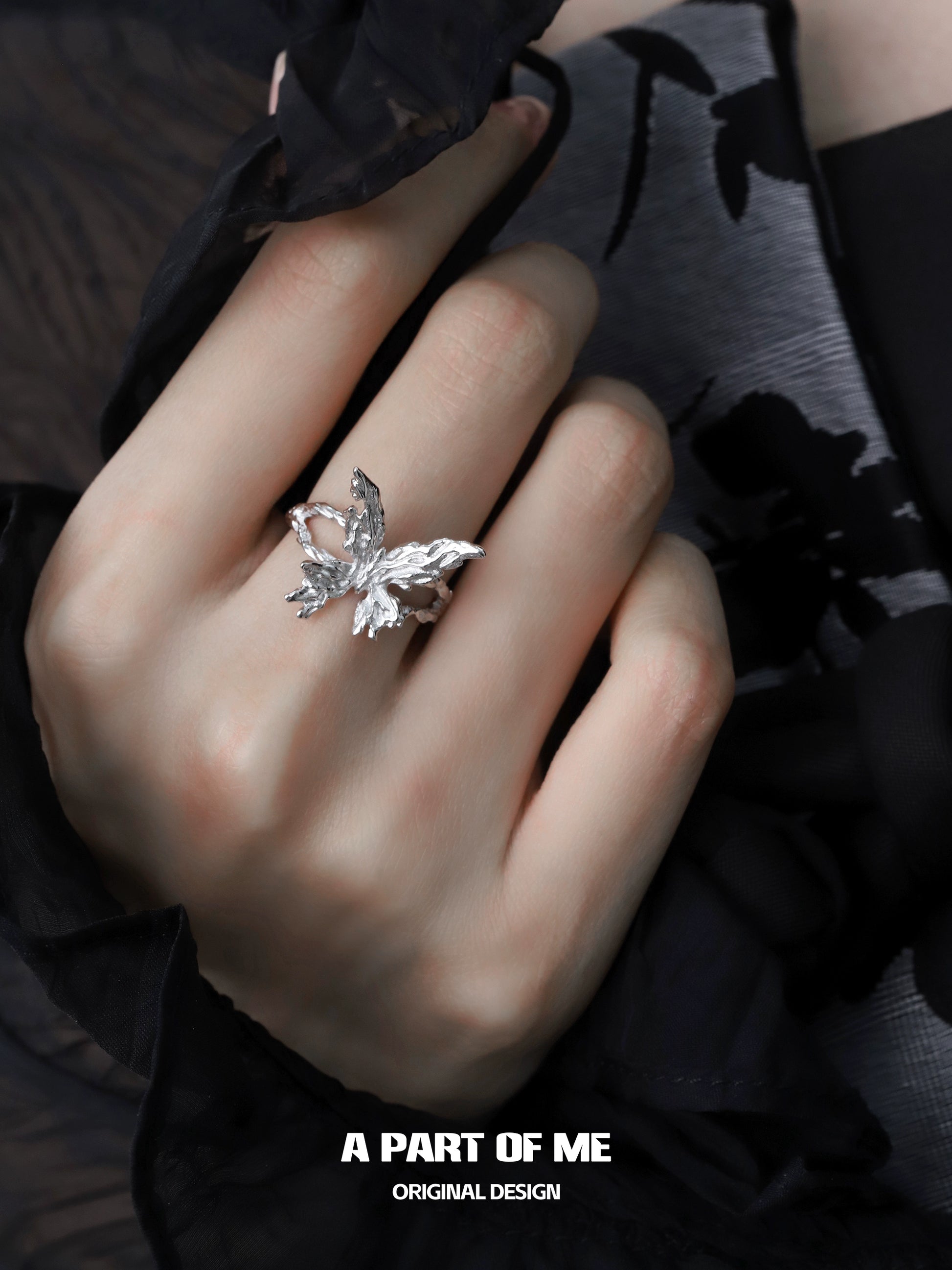 A PART OF ME butterfly silver ring featuring intricate design on a hand against a stylish background