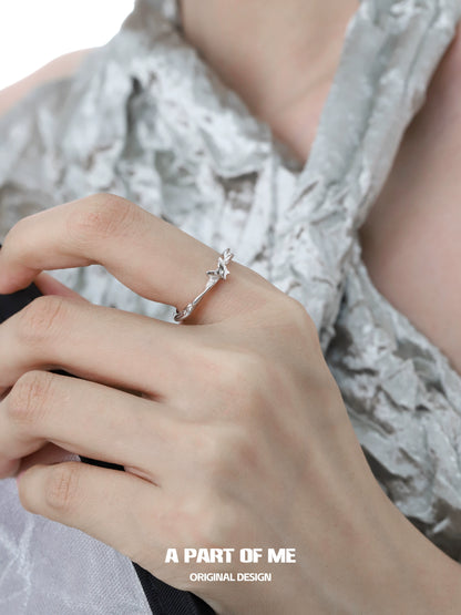 A delicate butterfly silver ring showcased on a model's hand with elegant fabric background