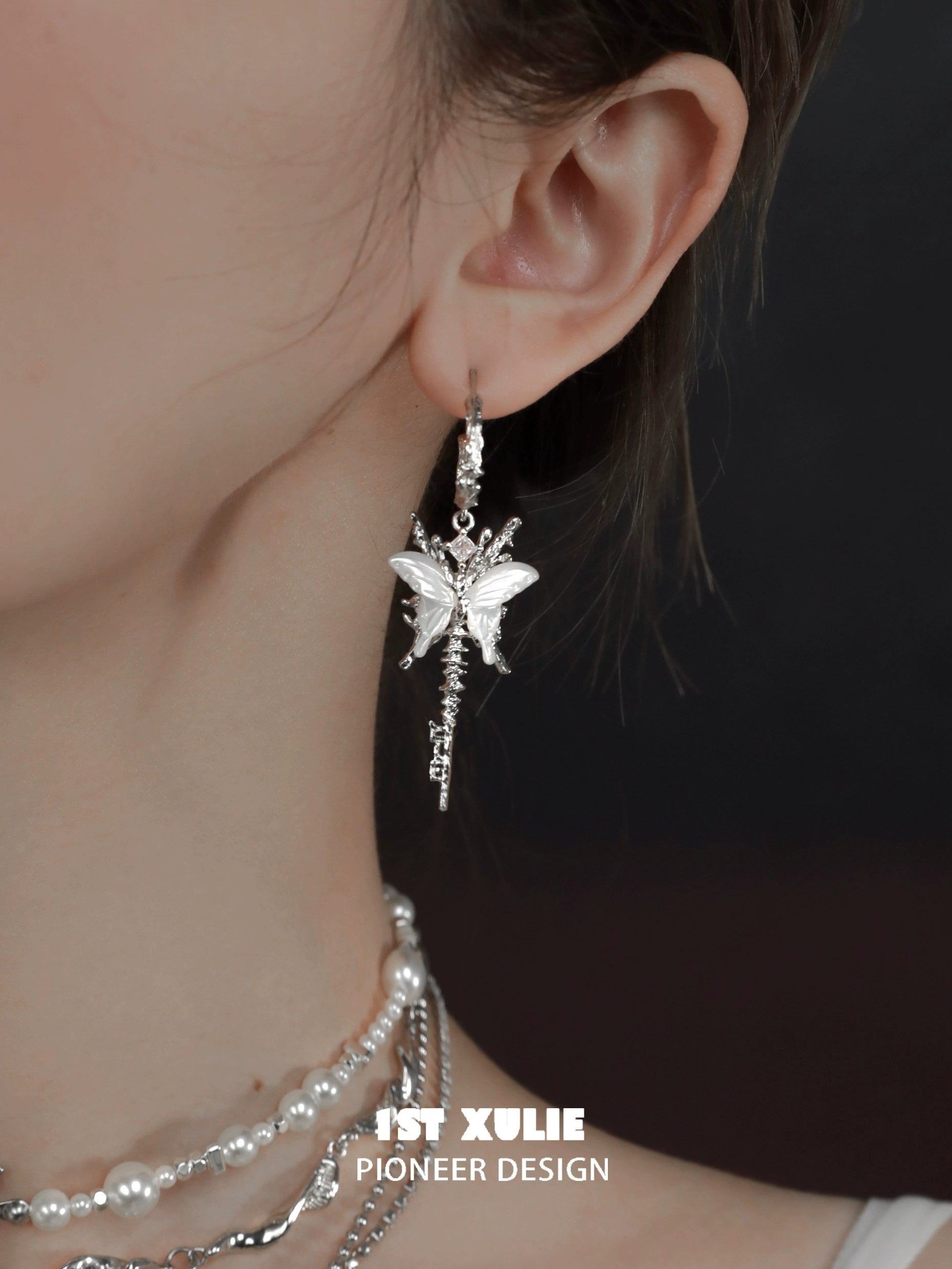 Silver butterfly tassel shell earrings dangling elegantly on a model's ear