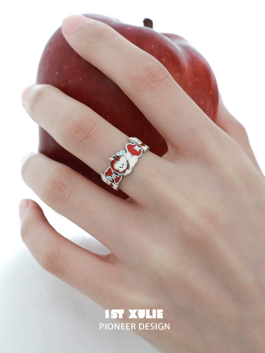 Stylish 1STXULIE cat and dog silver ring on a hand holding a red apple