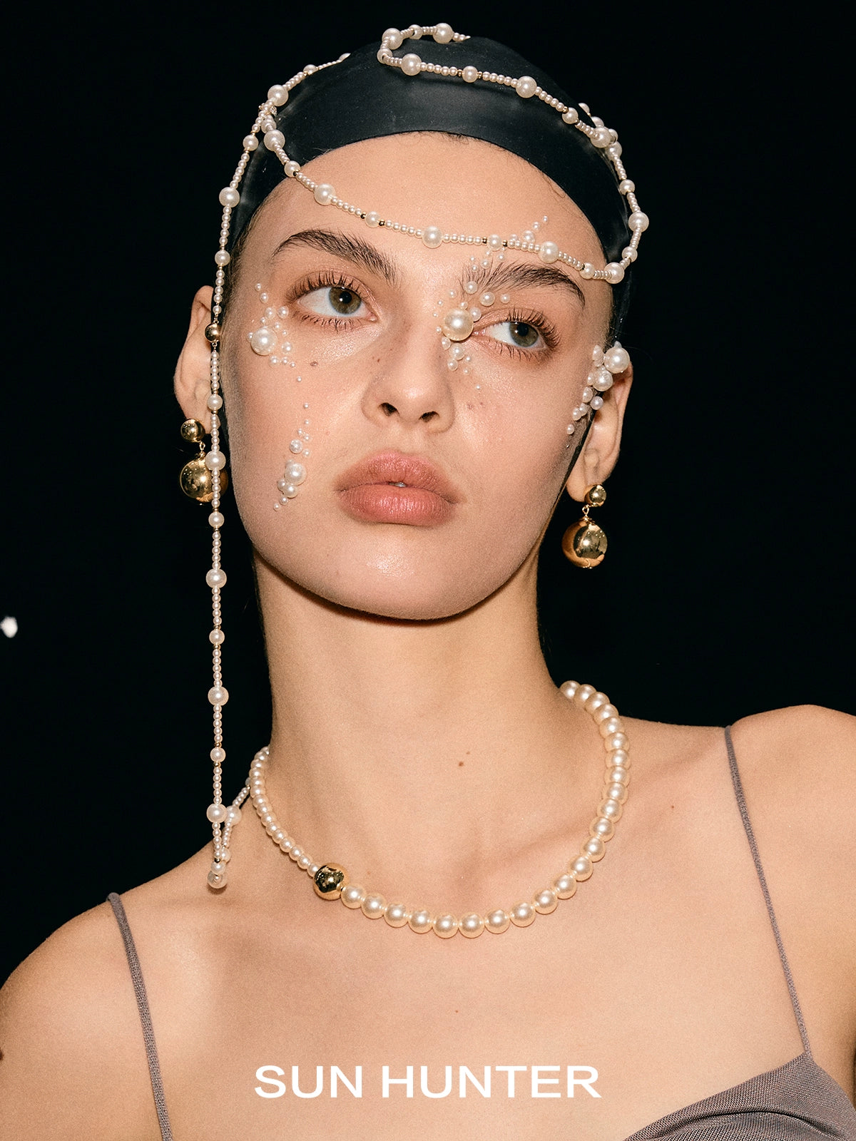 Elegant celestial planet gravity earrings from SUN HUNTER featured on a model with pearl accessories