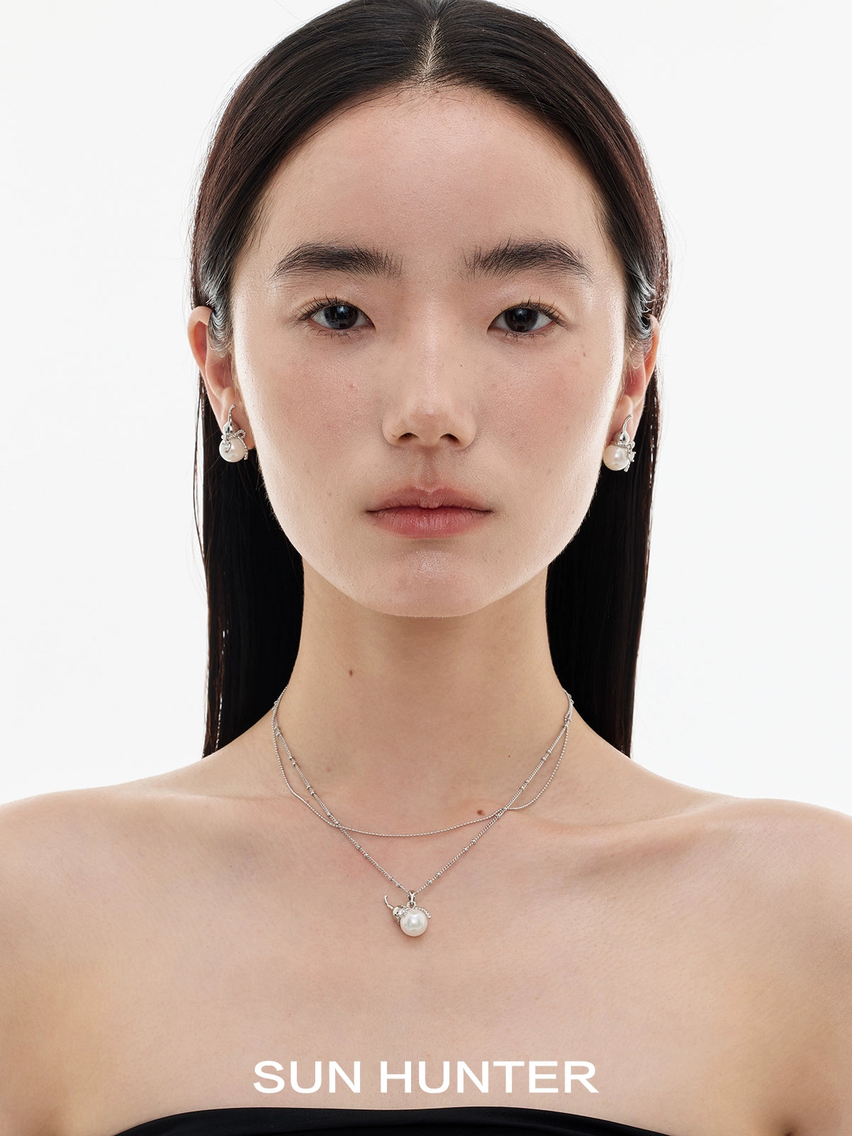 Elegant model wearing SUN HUNTER Chinese fortune gourd earrings styled with a minimalist necklace