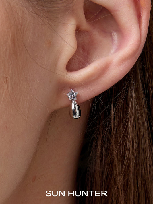 Silver SUN HUNTER cosmic planet earrings set on a model's ear for a stylish and modern look