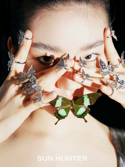 Model showcasing the SUN HUNTER double-layer butterfly ring among multiple butterfly rings on her fingers