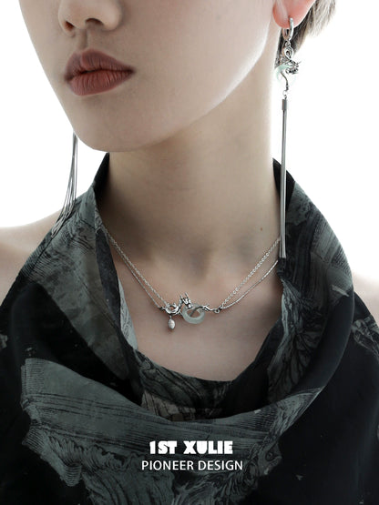 Elegant model showcasing a dragon silver necklace layered with delicate chains and unique charm detail