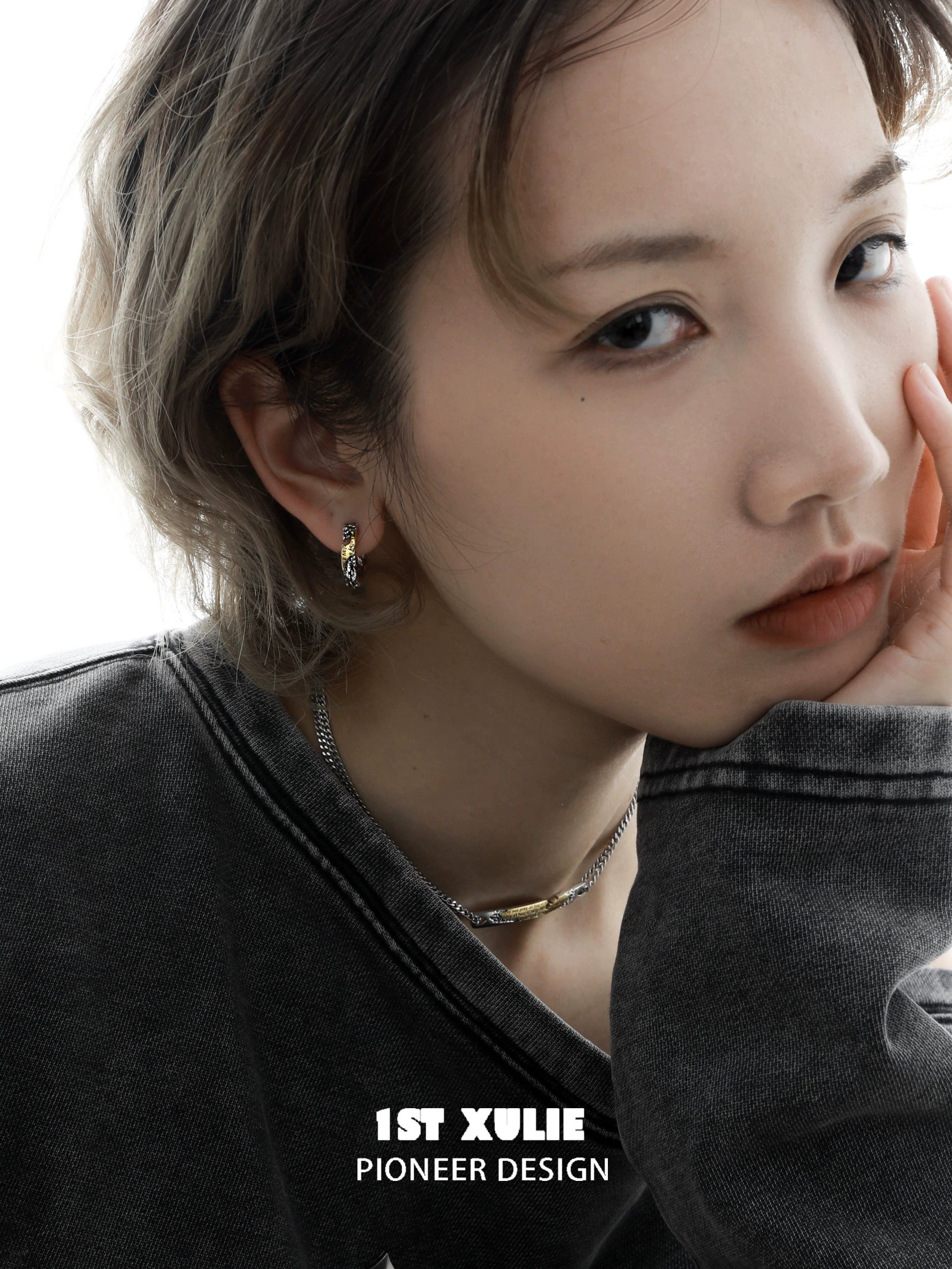 Stylish model wearing edgy love letter earrings with a modern chic aesthetic