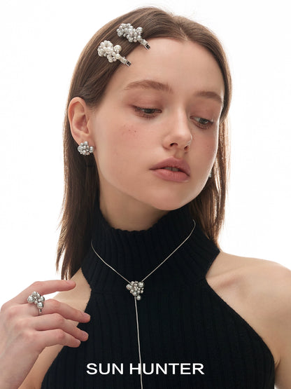 Elegant pearl statement ring worn by a model with matching pearl accessories and a black top