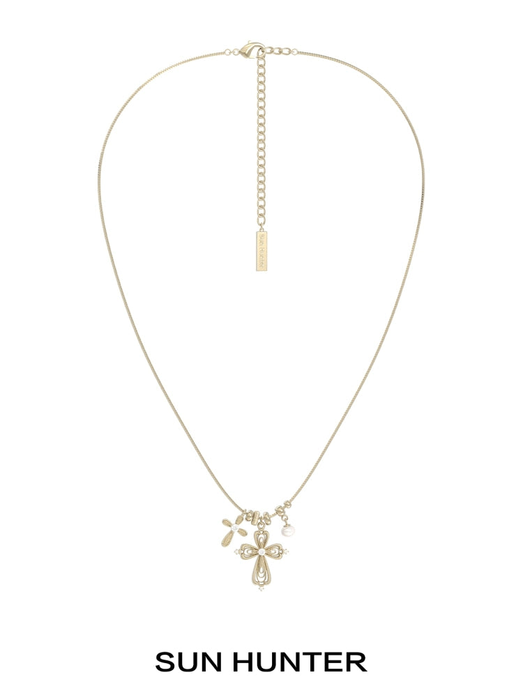 Sun Hunter faith charm necklace featuring a delicate cross and charm design in gold
