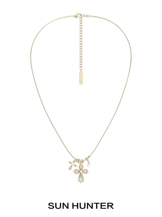 Sun Hunter faith charm necklace featuring a delicate cross and charm design in gold