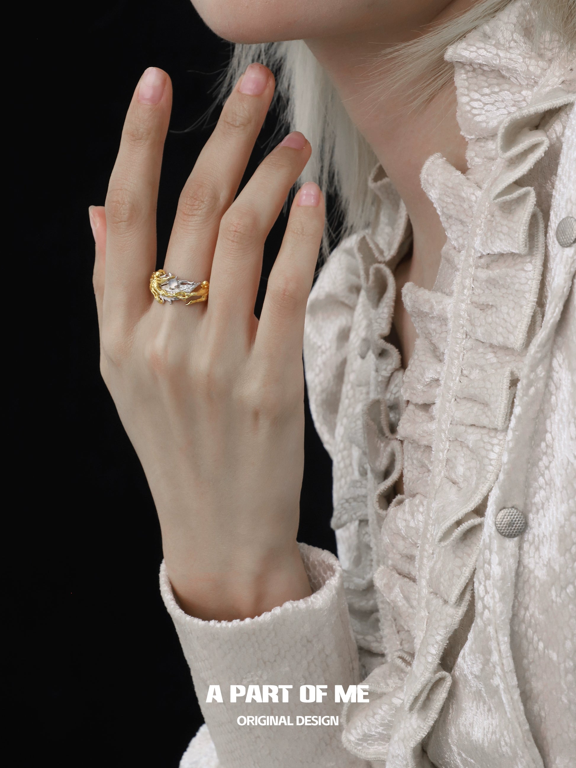 Elegant feather agate ring showcased on a model's hand against a dark background