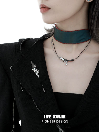 Elegant feather couple brooch displayed on a black jacket with chic accessories, perfect for stylish outfits