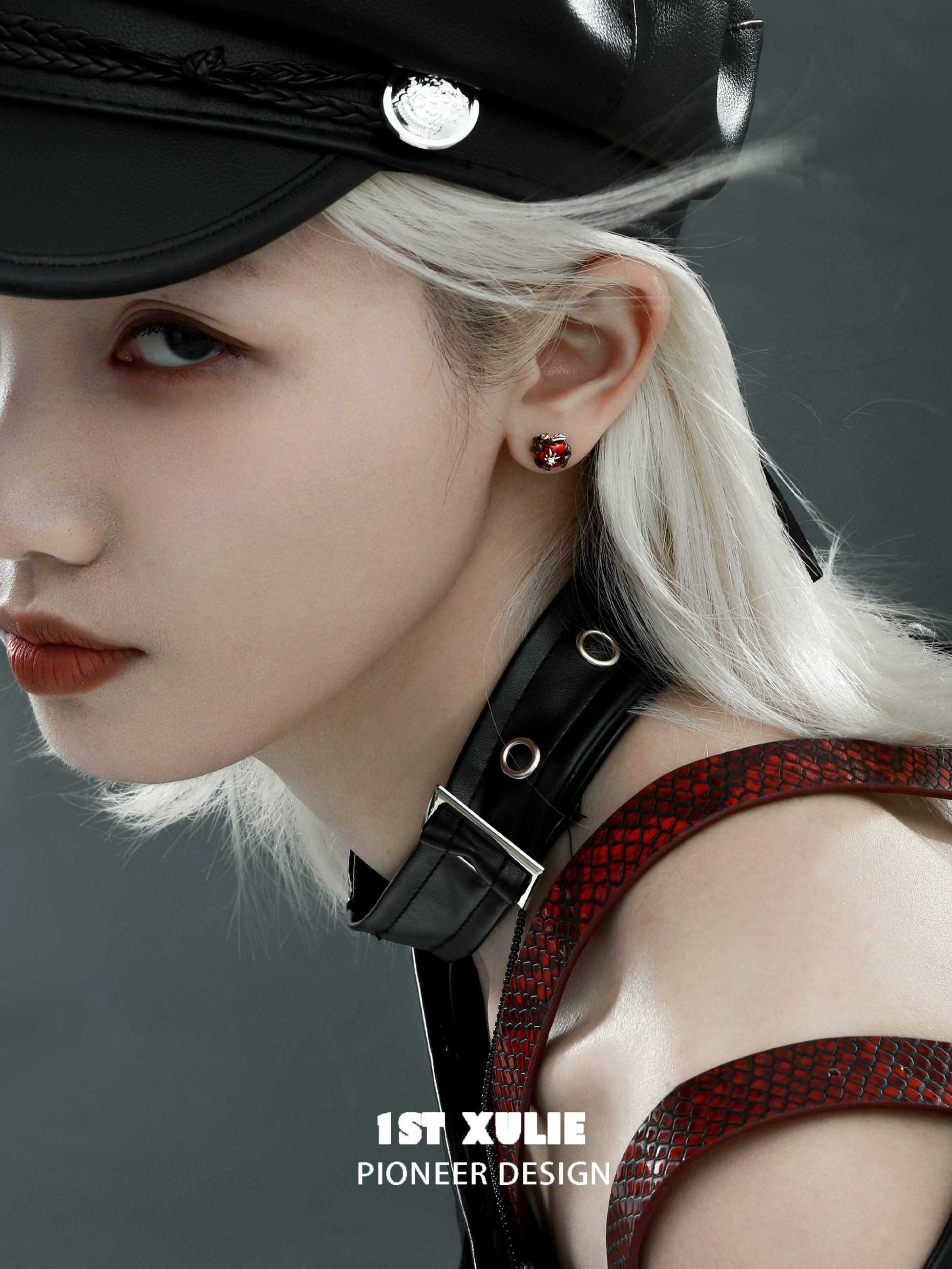 Model wearing 1STXULIE forbidden apple serpent earrings close-up with edgy fashion details