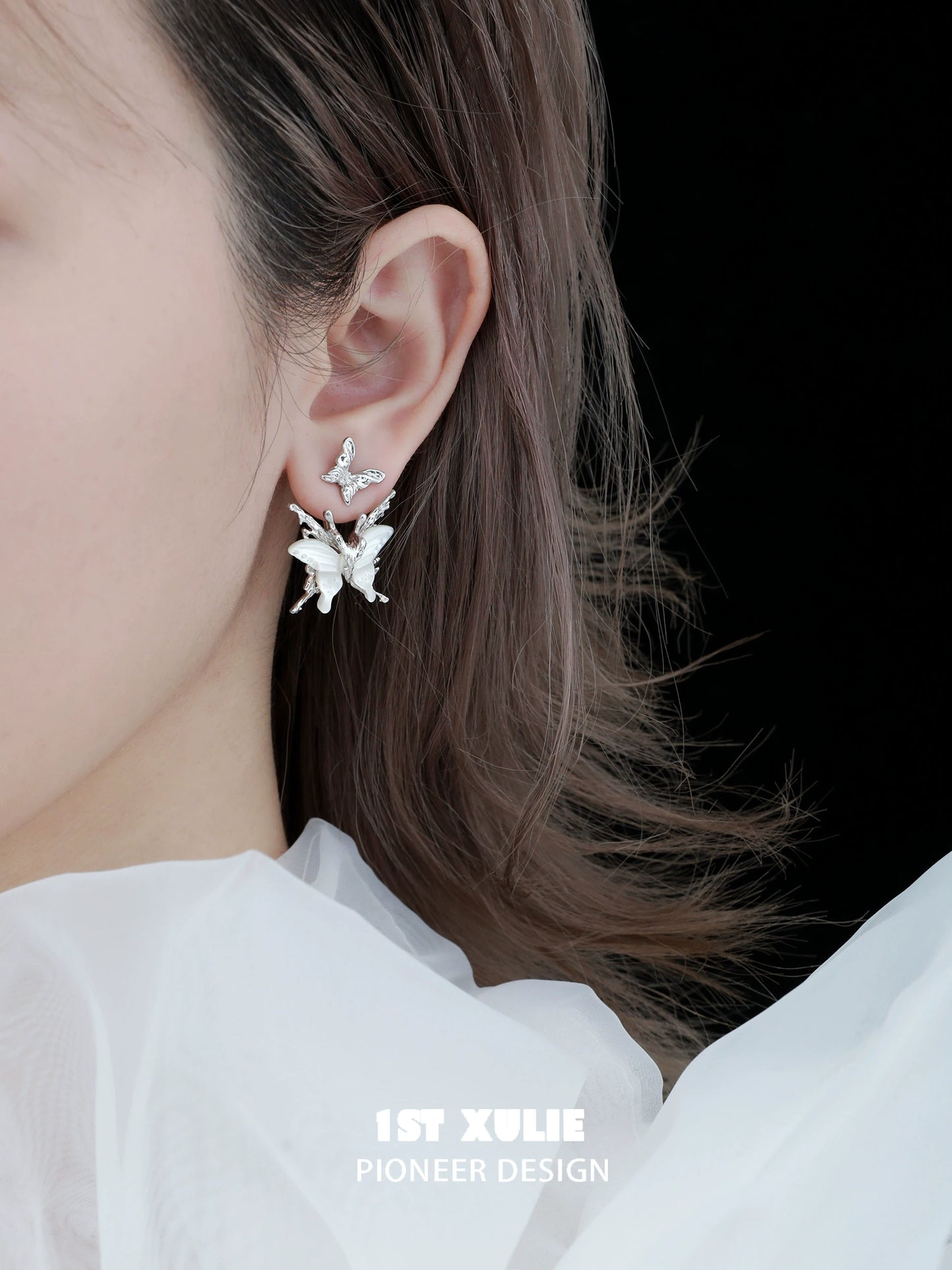 Futuristic butterfly earrings in silver design showcasing intricate details worn by a model