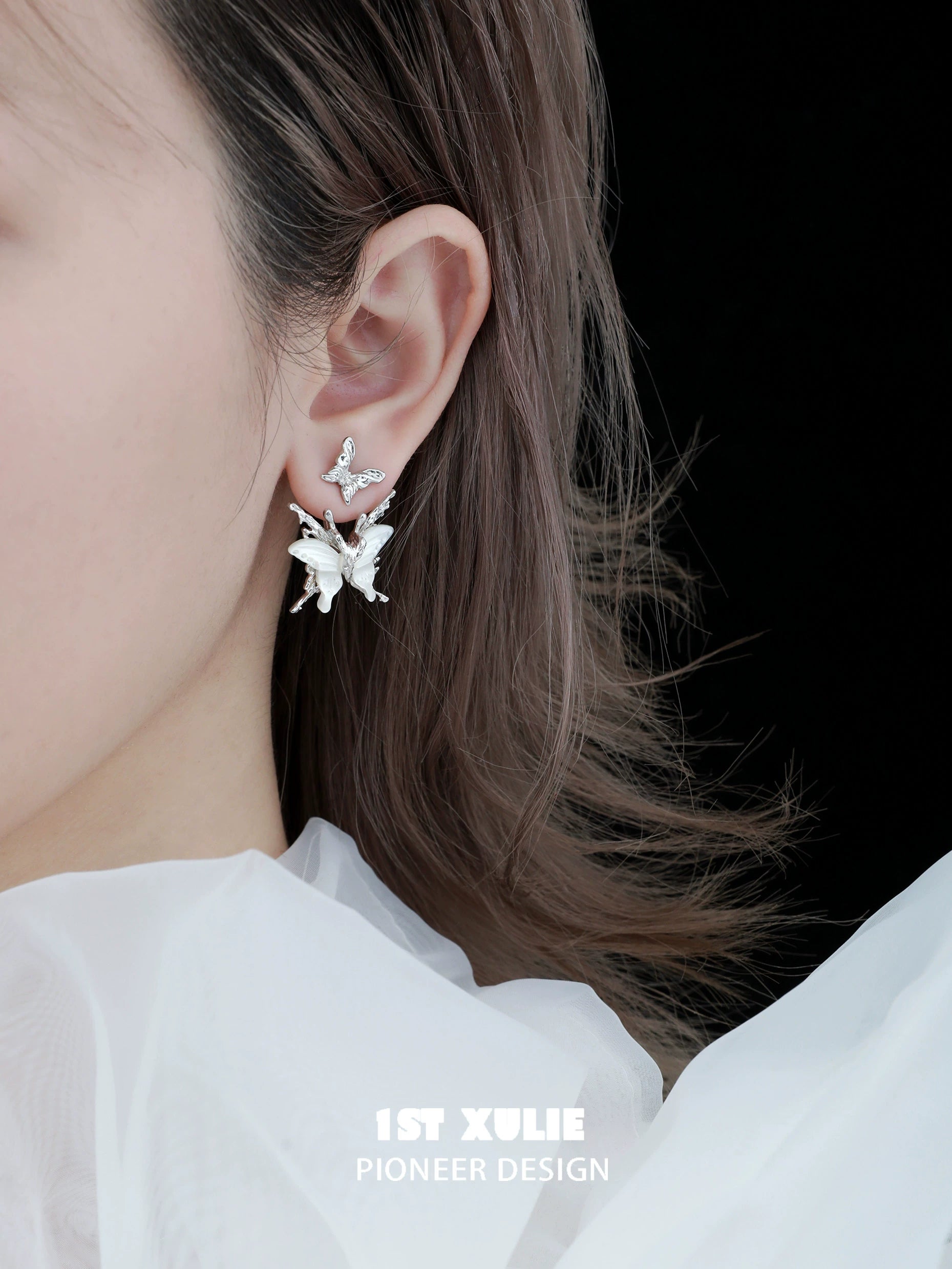Futuristic butterfly earrings in silver design showcasing intricate details worn by a model