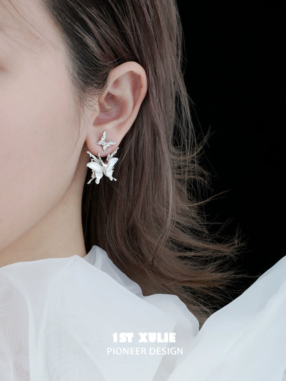 Futuristic butterfly earrings in silver design showcasing intricate details worn by a model