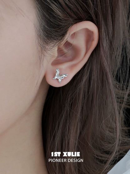 1STXULIE futuristic butterfly earrings in silver design, elegantly displayed on a model's ear
