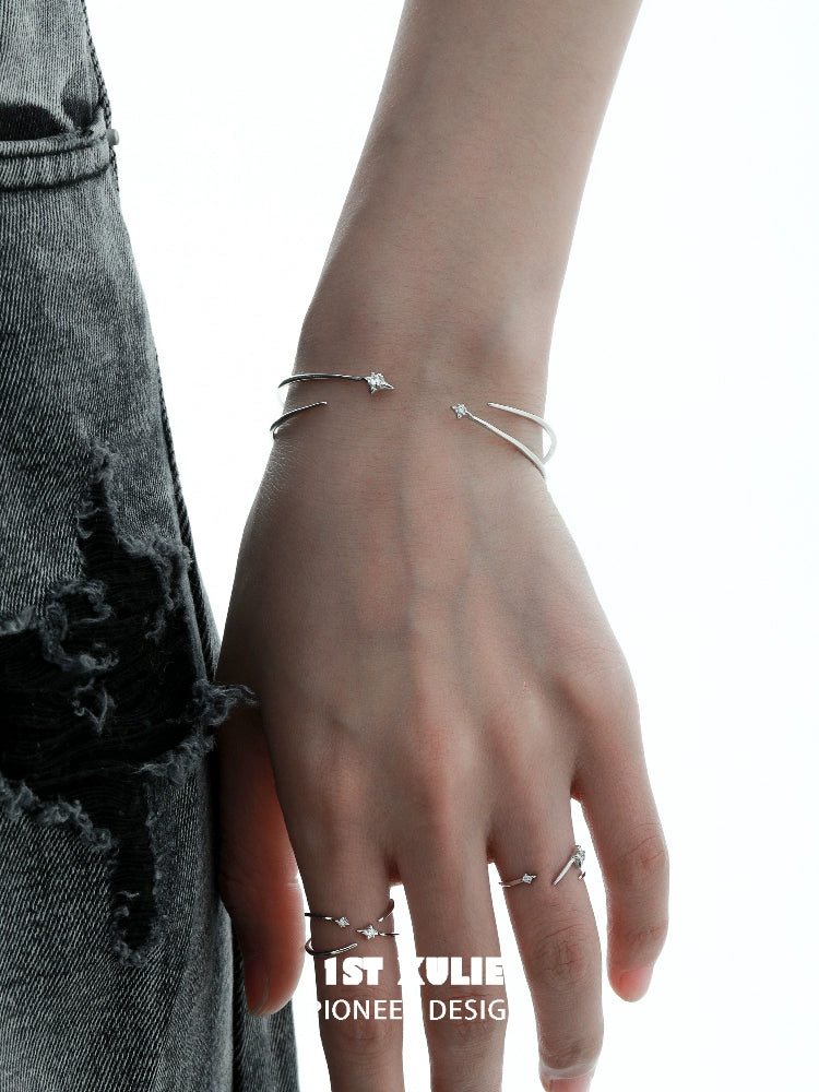Stylish hand wearing a futuristic silver bracelet alongside matching rings for contemporary fashion.