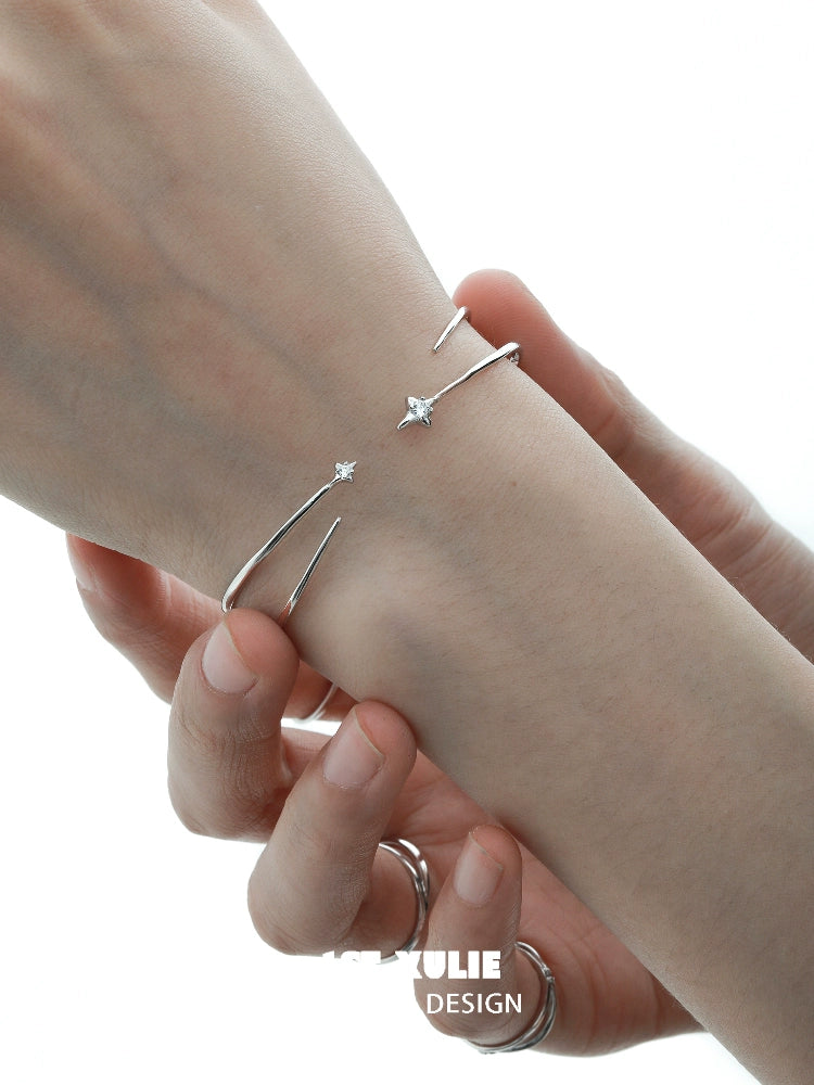 Model wearing a futuristic silver bracelet featuring minimalist design and sparkling details