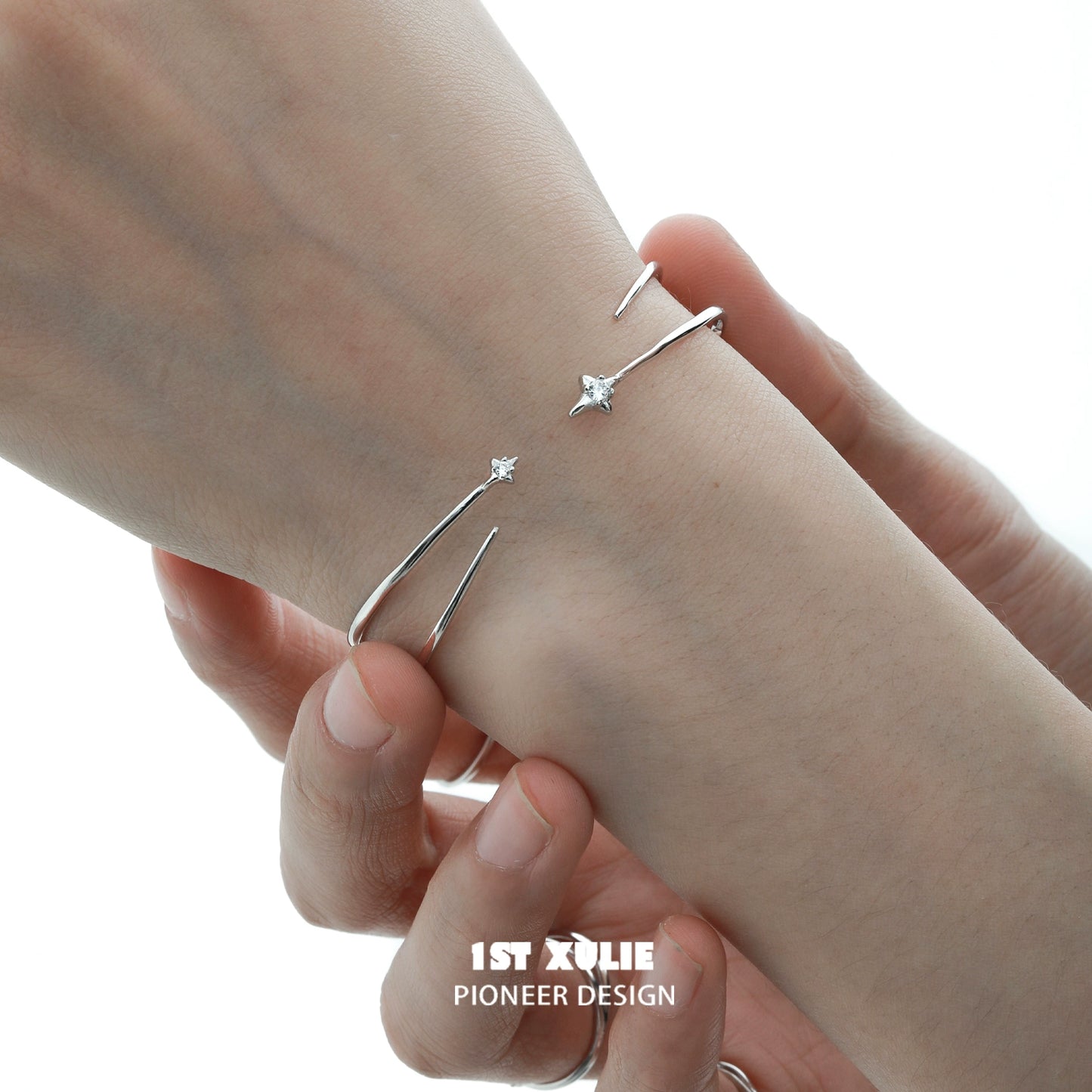 Minimalist design of a futuristic silver bracelet with delicate star accents on a wrist