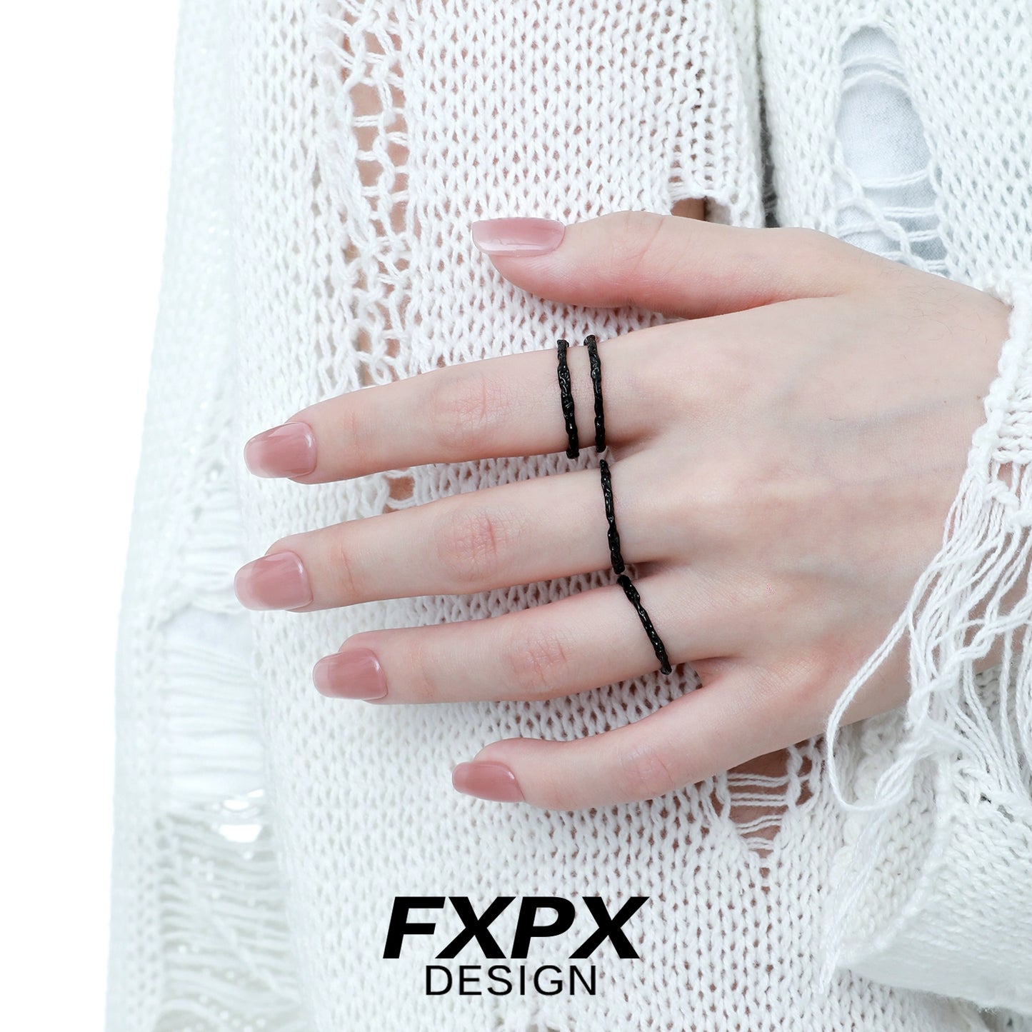 FXPX black tinfoil texture ring displayed on a model's hand with a stylish outfit