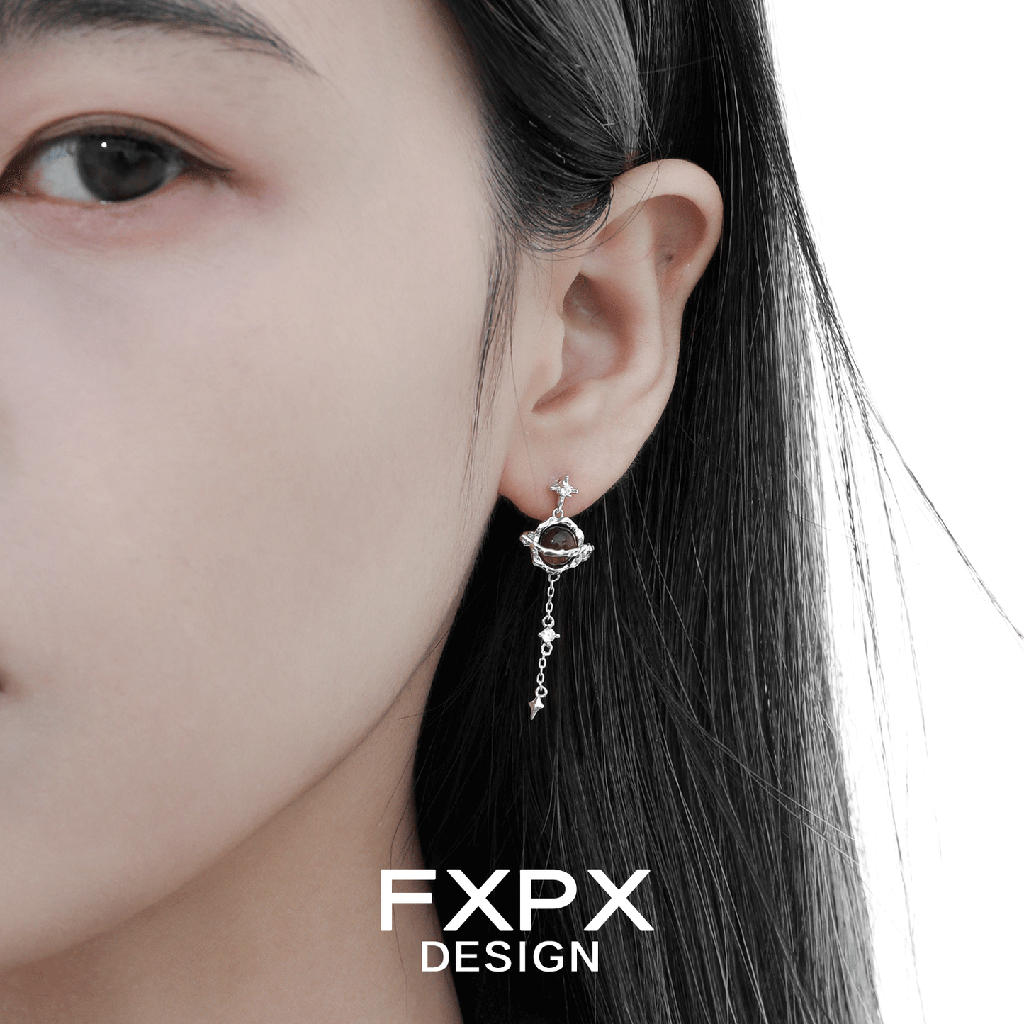 Bloody Doll Jewelry Gothic Saturn tiger eye earrings worn on a woman ear with silver chain detail