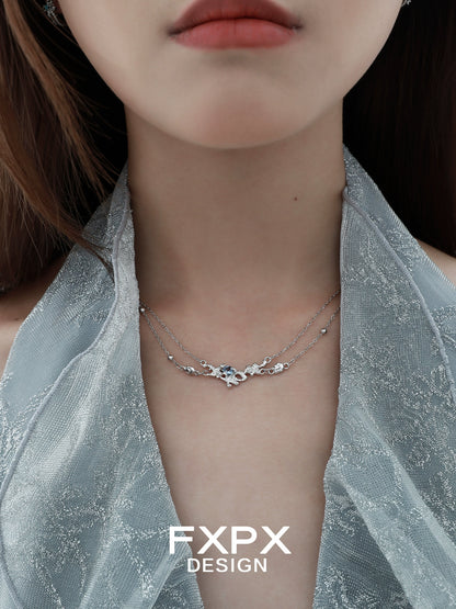 Elegant blue crystal necklace layered with delicate silver chains for a stunning look