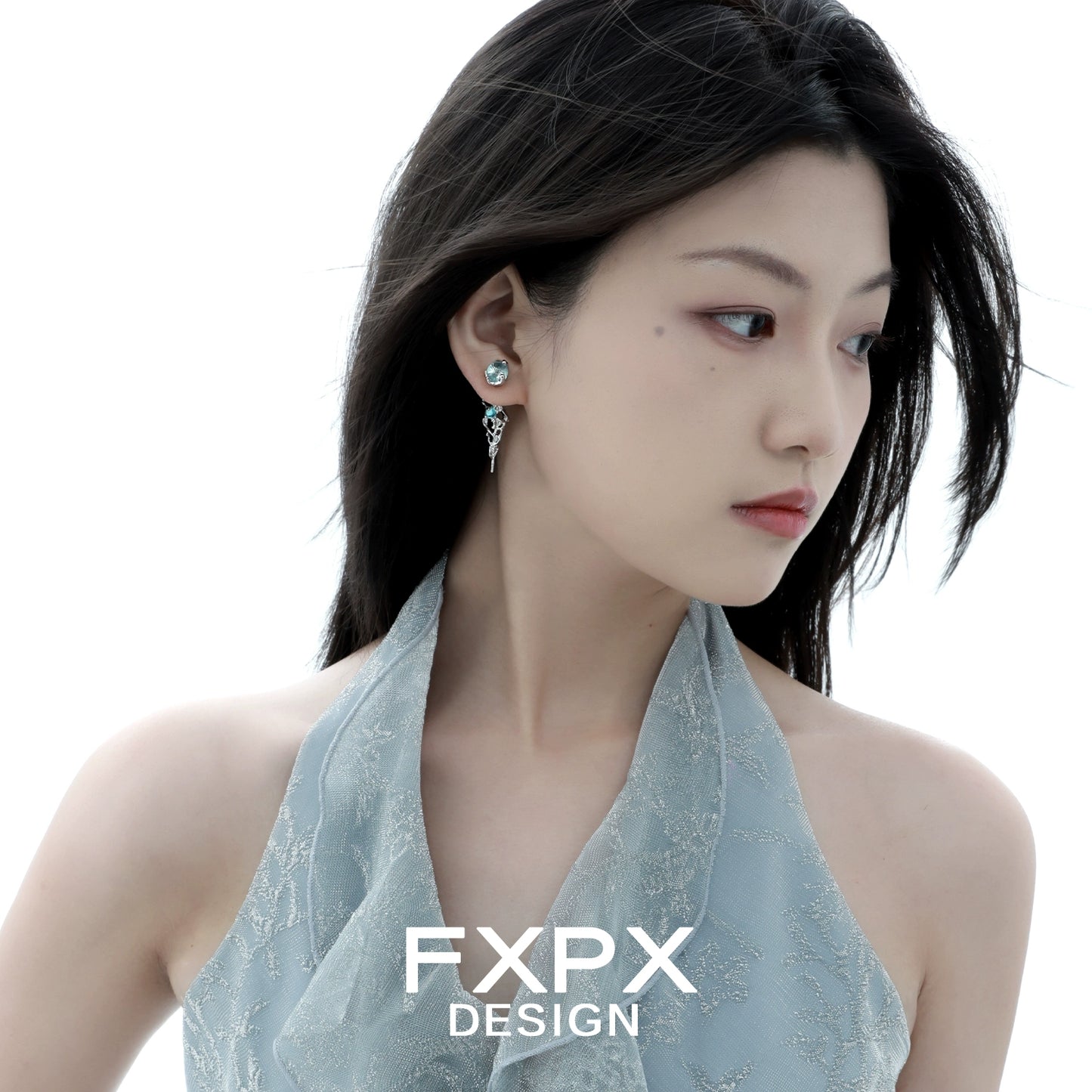 Elegant blue glacier earrings showcased on a model with a soft hairstyle and stylish outfit
