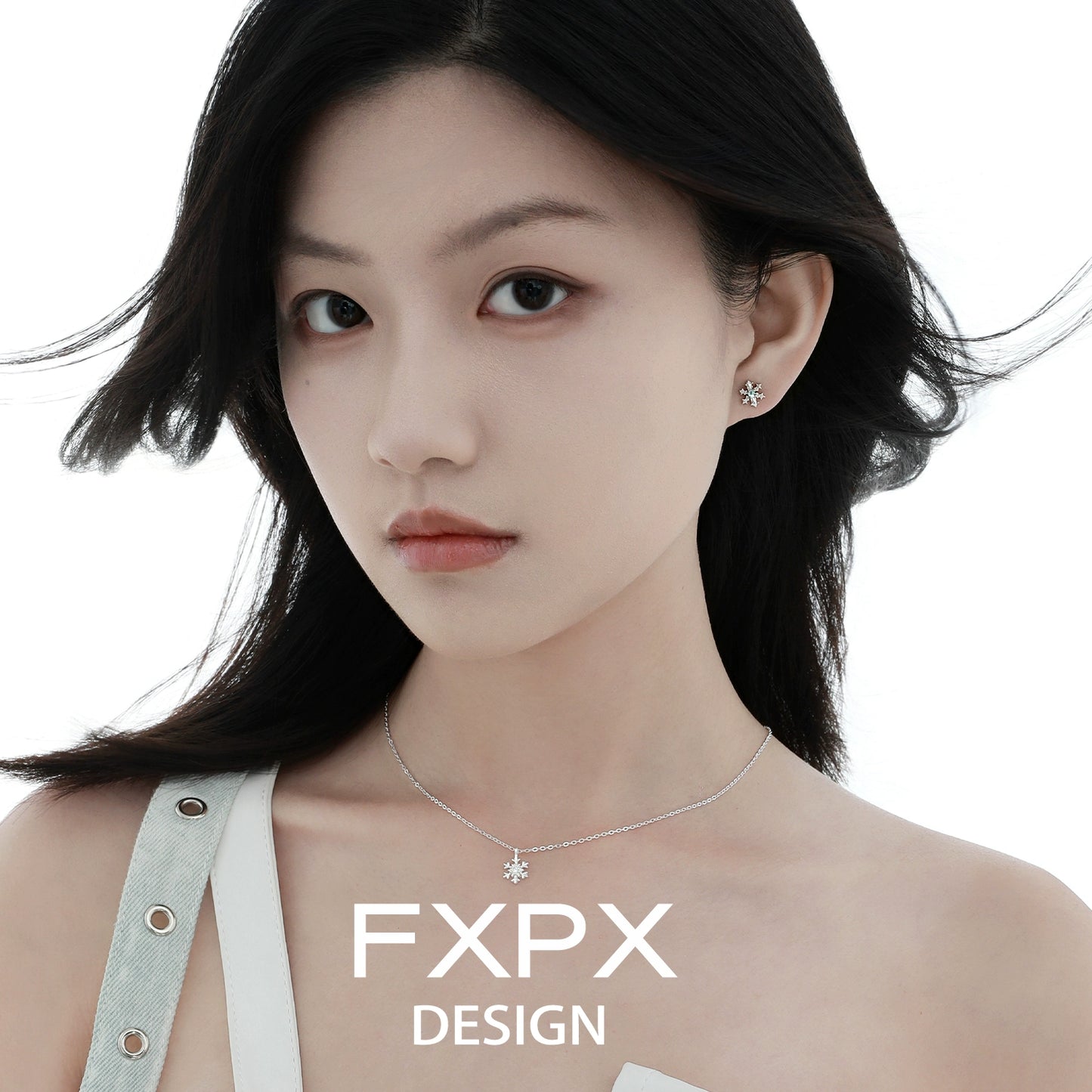 Stylish model wearing FXPX blue snowflake earrings with a delicate necklace for a chic look