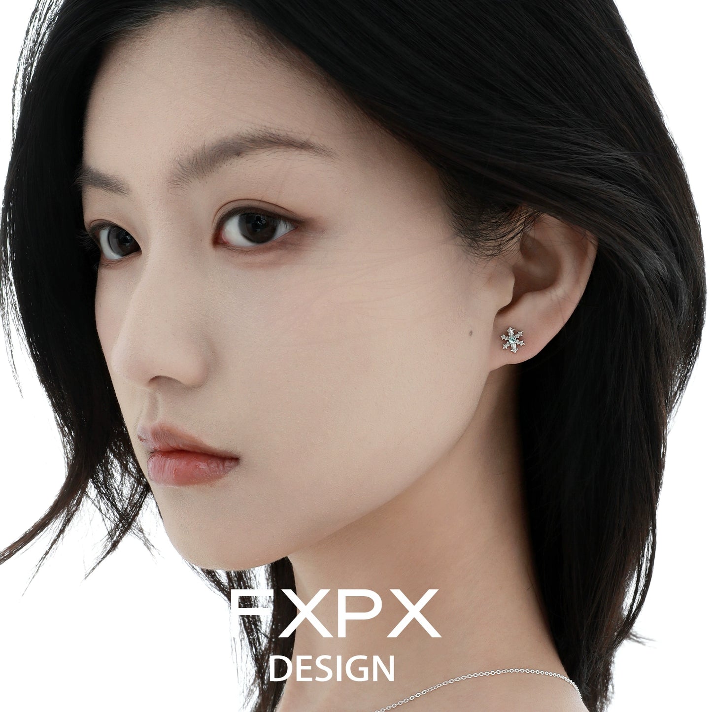 Elegant FXPX blue snowflake earrings showcased on a model's ear for a winter-themed look