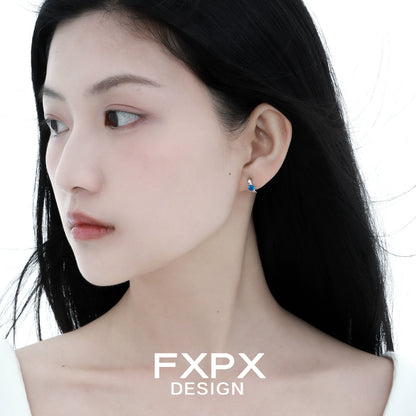 Elegant blue zircon earrings showcased on a model with long dark hair and a soft expression