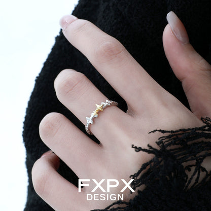 FXPX gold star ring on a hand with a stylish black outfit, featuring a unique design