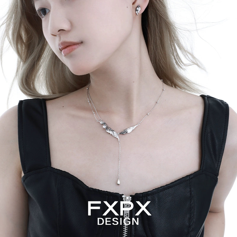 FXPX gothic angel wing earrings in silver design, stylishly worn with a black top for a bold look