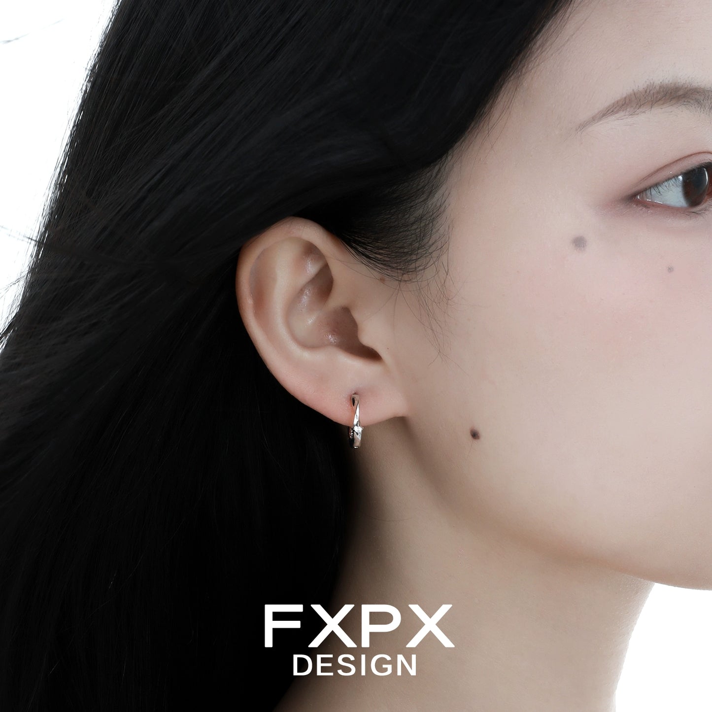 Silver FXPX gothic cross earrings stylishly worn on a woman's ear