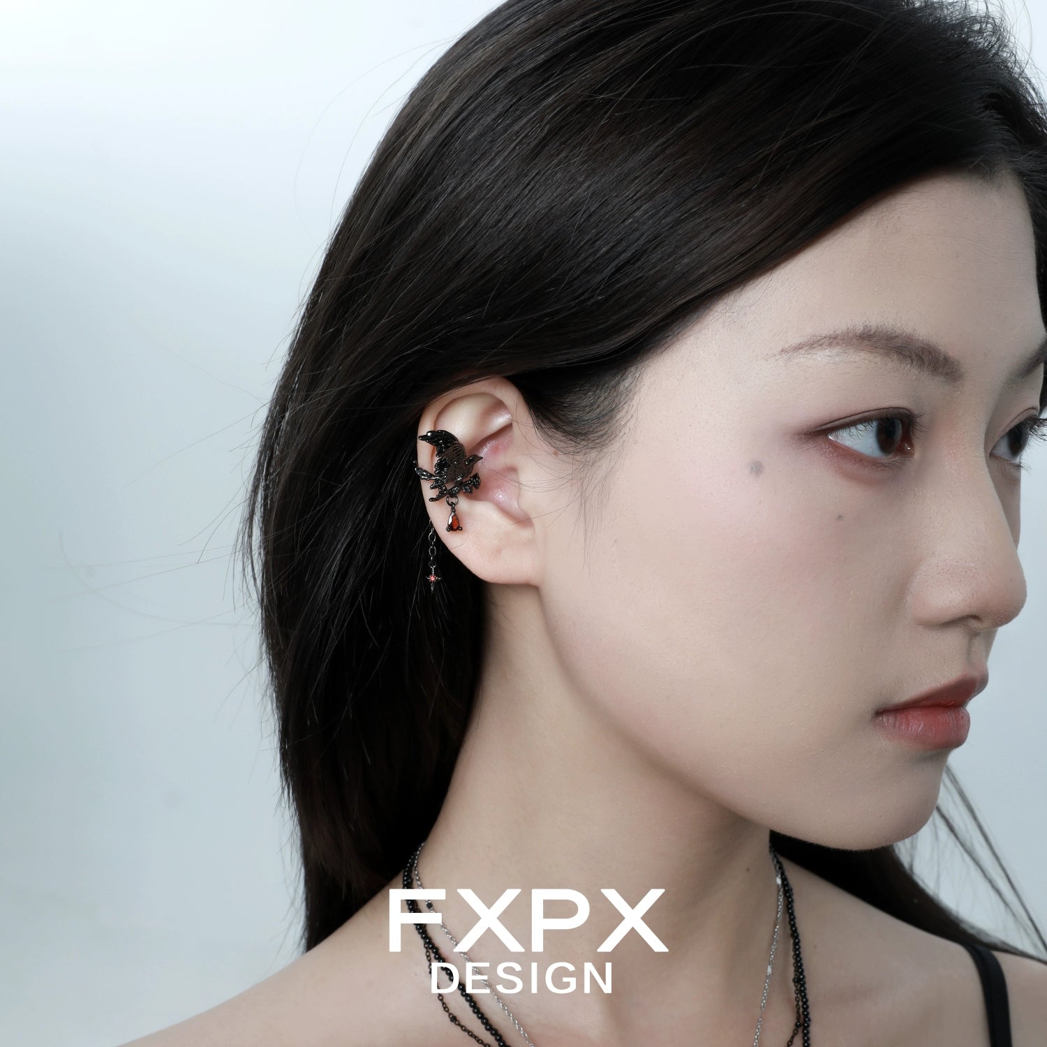 Gothic crow ear cuffs in silver with intricate details worn on the model's ear for a stylish look
