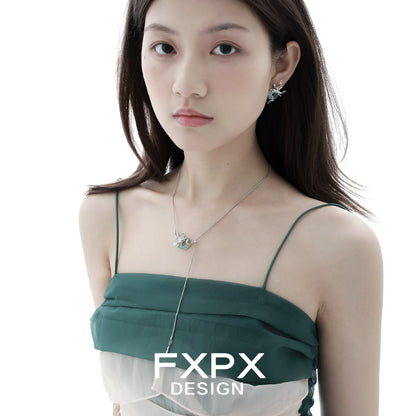 Iris safety buckle necklace worn by model with elegant green dress and stylish earrings
