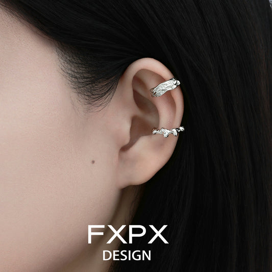 Irregular silver earrings displayed on a model's ear showcasing unique textured design by FXPX