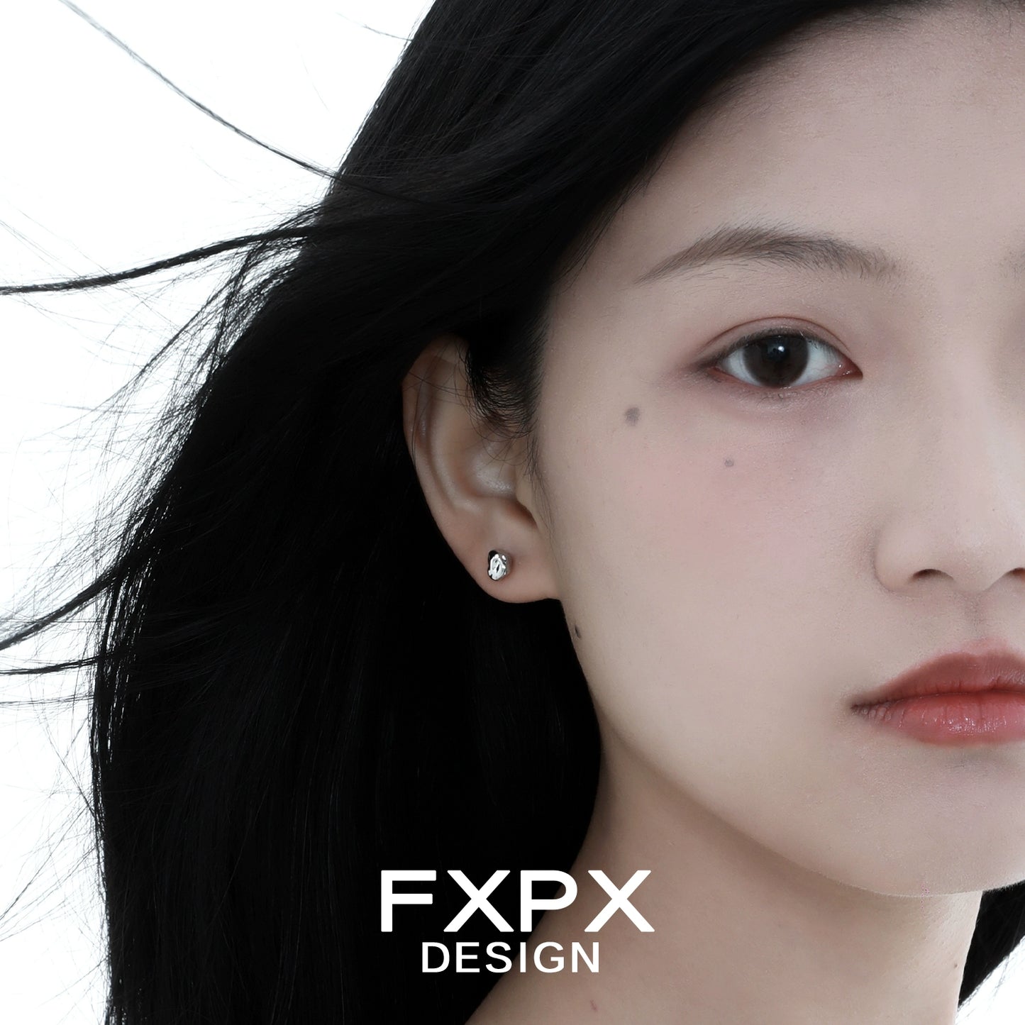 Stylish FXPX meteorite stud earrings showcasing a sleek and modern design on a model's ear