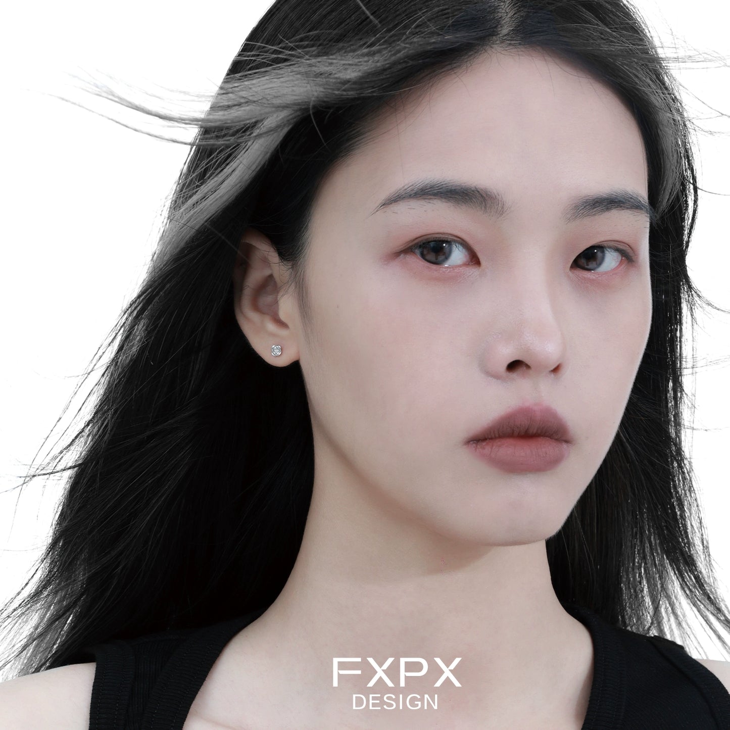 Minimal rose silver earrings worn by a model with long dark hair and a neutral expression