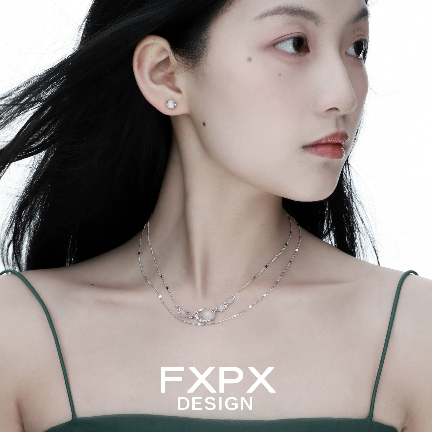 Model wearing a minimalist agate necklace layered with silver chains for a chic look