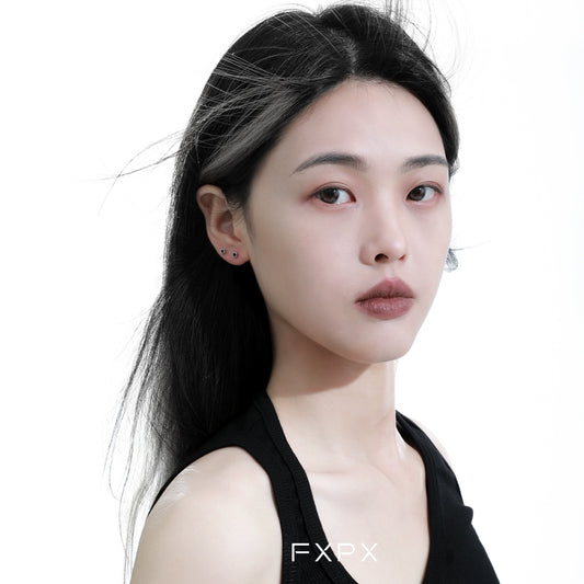 Elegant minimalist black and white earrings showcased on a model with flowing black hair