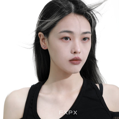 Elegant minimalist black and white earrings paired with a stylish black top, exuding modern sophistication