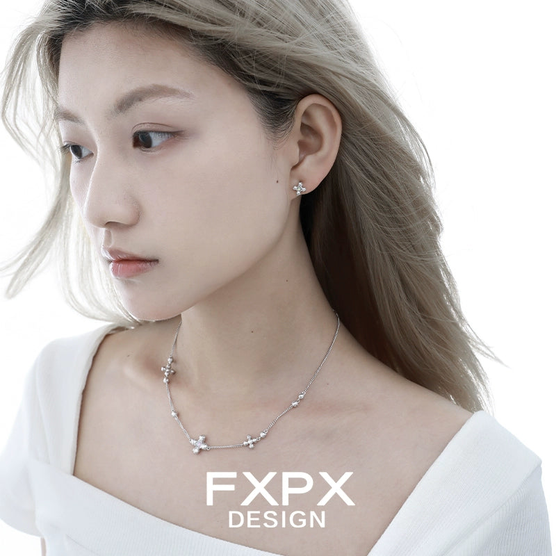 Elegant minimalist cross earrings from FXPX showcased on a model with wavy hair