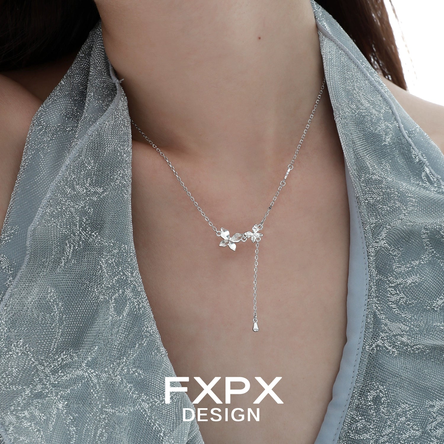 Elegant FXPX mirror butterfly pendant necklace displayed on a model's neck in soft lighting