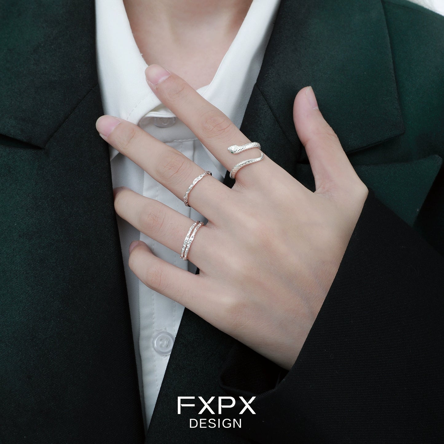 Stylish Ouroboros silver ring worn on a finger with other delicate rings for a modern look