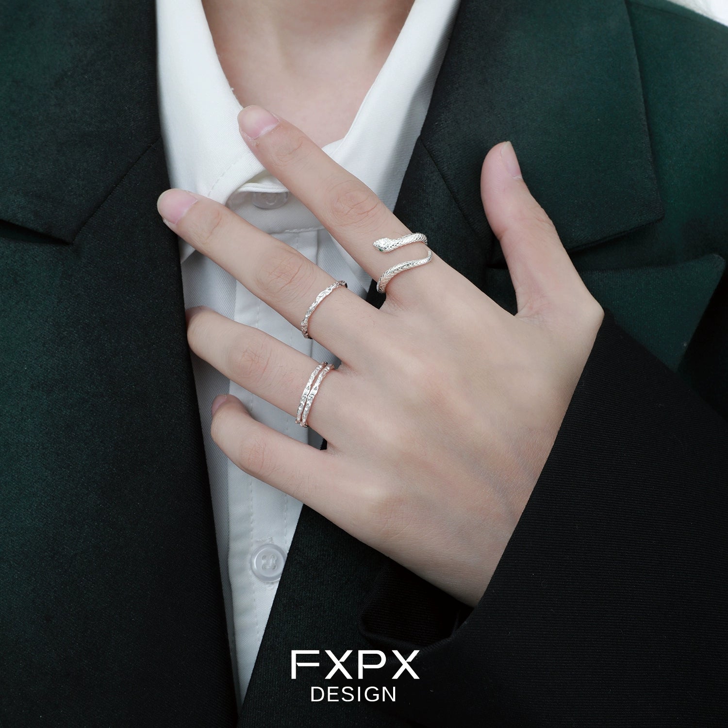 Stylish Ouroboros silver ring worn on a finger with other delicate rings for a modern look