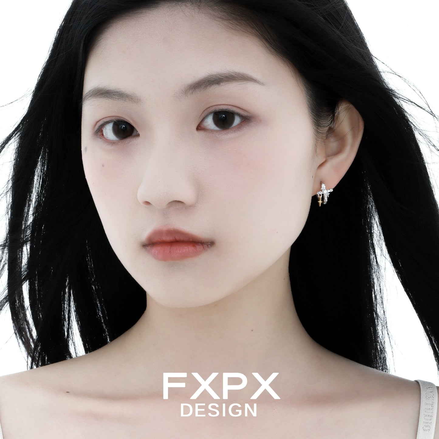 Elegant FXPX silver axis cross earrings worn by a model with flowing hair