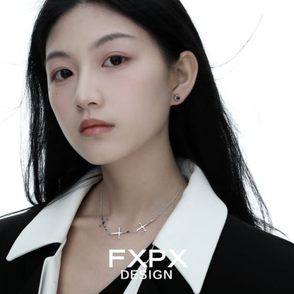 Elegant FXPX silver cross necklace worn by a model against a white background