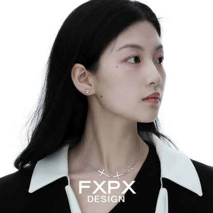 Elegant FXPX silver cross necklace showcased on a model with sleek hair and minimalistic earrings